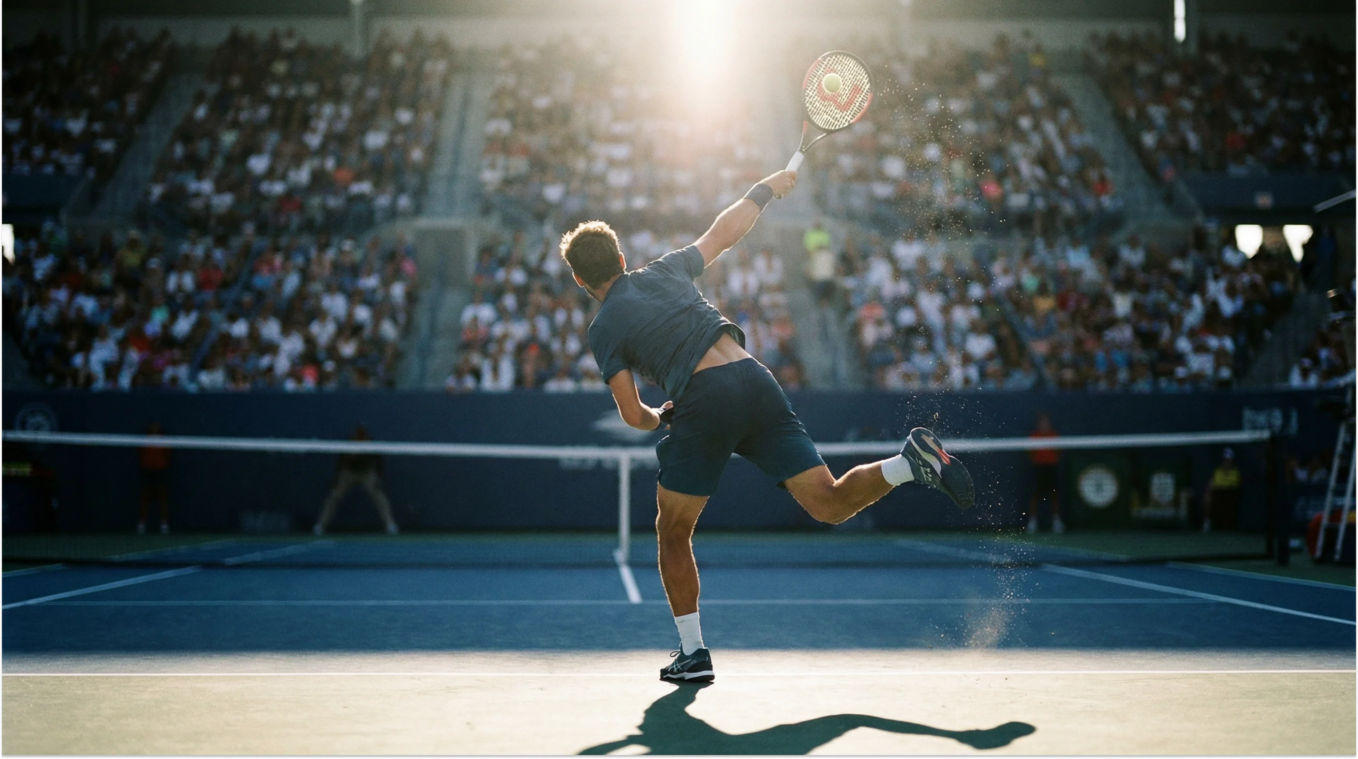 Tennisspieler beim kraftvollen Aufschlag auf einem Hartplatz vor vollen Tribünen