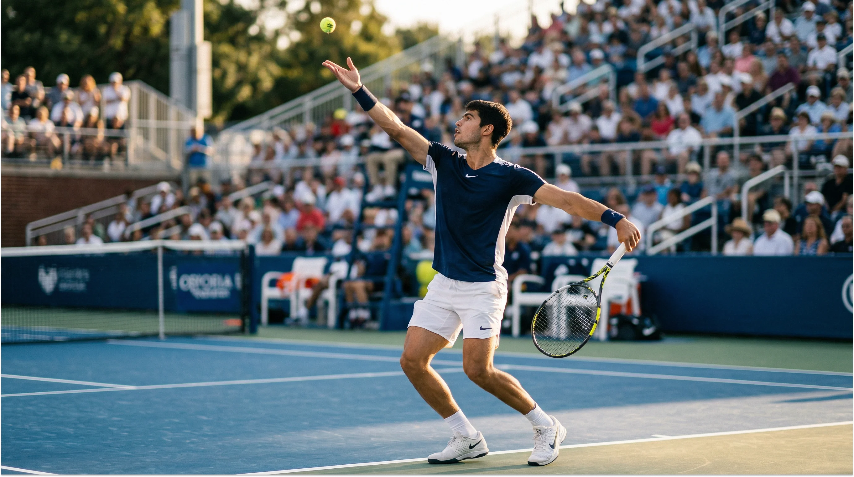 Tennisspieler steht an der Grundlinie eines Hartplatzes und bereitet den Aufschlag vor